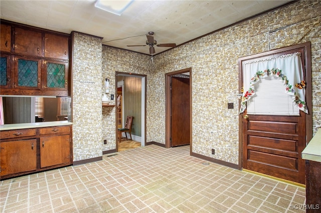 kitchen featuring brick floor, baseboards, a ceiling fan, and light countertops