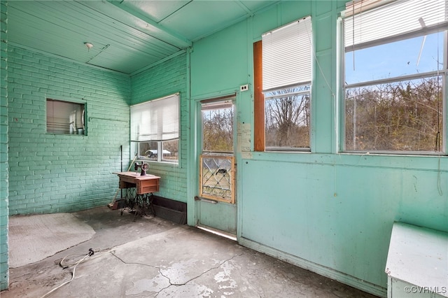 interior space with concrete flooring and brick wall