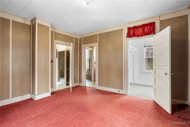 unfurnished bedroom featuring wooden walls and carpet flooring