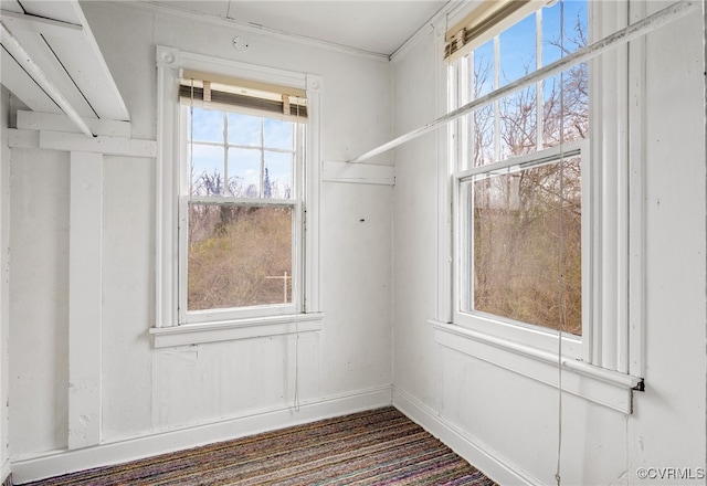 unfurnished room featuring baseboards and plenty of natural light