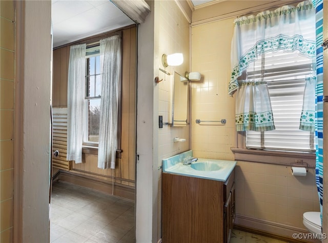 bathroom with vanity, tile walls, and toilet