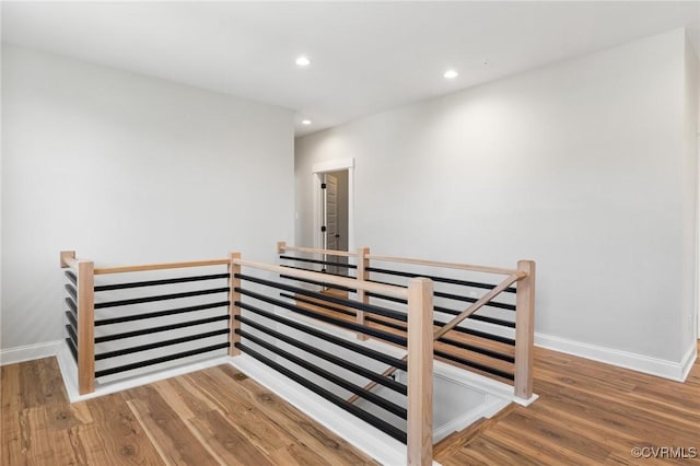 staircase featuring recessed lighting, baseboards, and wood finished floors