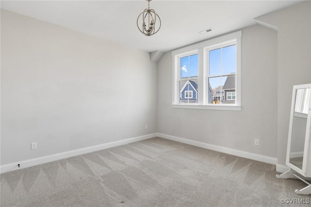 carpeted empty room featuring visible vents, baseboards, and a chandelier