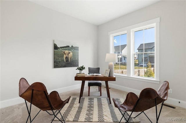 office featuring visible vents, baseboards, and light carpet