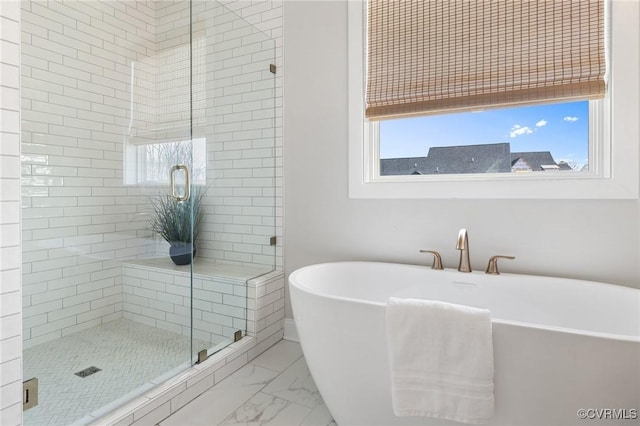 bathroom featuring a shower stall, marble finish floor, and a freestanding bath