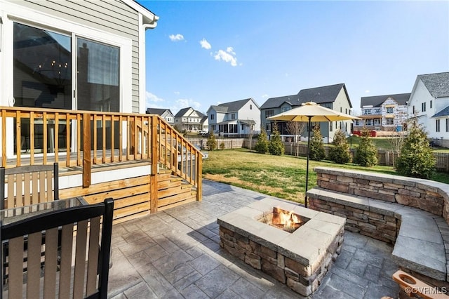 view of patio / terrace with a residential view, fence, a deck, and an outdoor fire pit