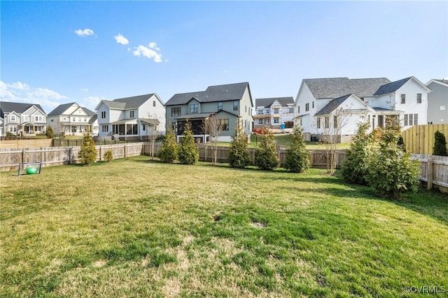 view of yard featuring a fenced backyard and a residential view