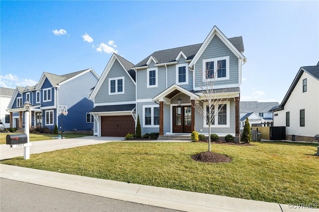 view of front of home featuring a residential view, driveway, a front yard, and an attached garage