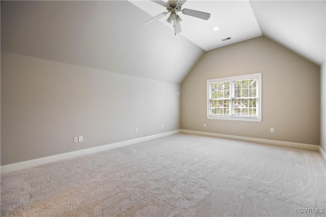 additional living space with visible vents, baseboards, vaulted ceiling, light carpet, and a ceiling fan