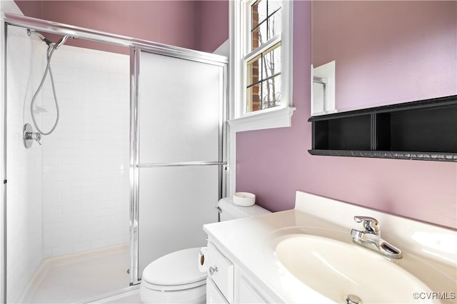 bathroom featuring vanity, a shower stall, and toilet