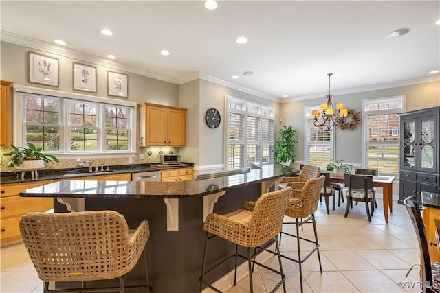 kitchen featuring light tile patterned floors, a sink, dishwasher, a notable chandelier, and tasteful backsplash