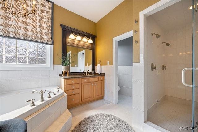 bathroom with tile patterned floors, toilet, a stall shower, a bath, and tile walls