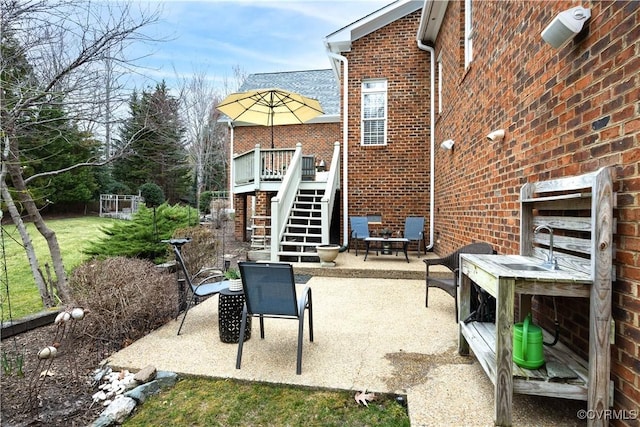 view of patio / terrace featuring a wooden deck, a fire pit, and stairs