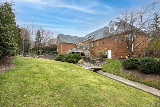 view of side of property with stairway, a lawn, and brick siding