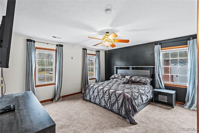 bedroom with baseboards, visible vents, ceiling fan, a textured ceiling, and carpet flooring