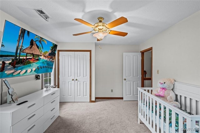 bedroom featuring visible vents, light carpet, a closet, baseboards, and ceiling fan