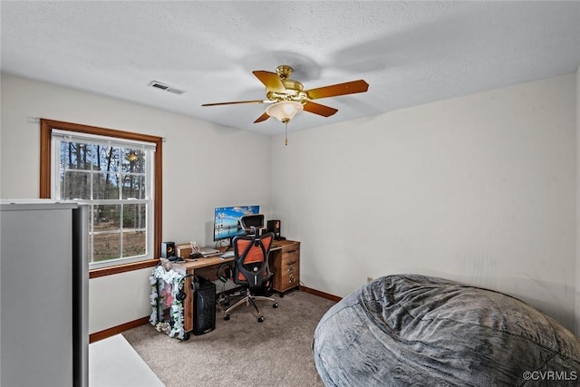 home office featuring visible vents, baseboards, ceiling fan, and carpet flooring