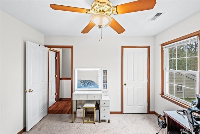 home office featuring visible vents, carpet flooring, baseboards, and a ceiling fan