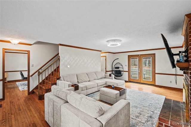 living room with stairway, wood finished floors, baseboards, and ornamental molding