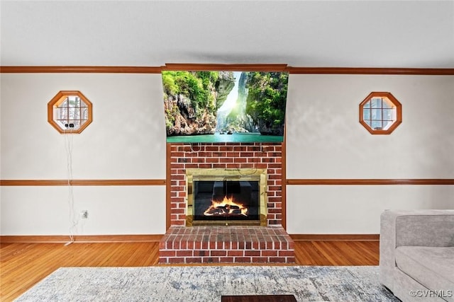 unfurnished living room with a brick fireplace, baseboards, and wood finished floors