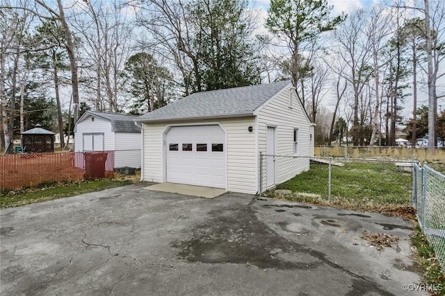 detached garage with fence and driveway