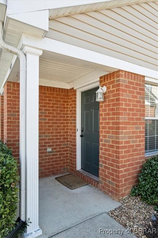 view of exterior entry with brick siding