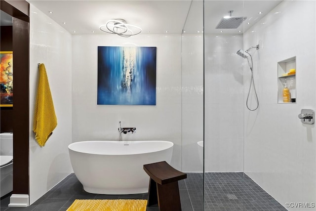 full bath featuring tile patterned floors, a soaking tub, a walk in shower, and toilet