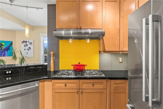 kitchen with pendant lighting, dark stone countertops, stainless steel appliances, decorative backsplash, and extractor fan