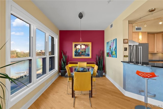 dining room with visible vents, baseboards, and light wood finished floors