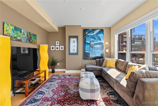 living room with visible vents, baseboards, a city view, and wood finished floors