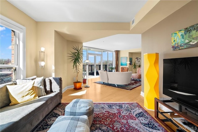 living area featuring wood finished floors, visible vents, and baseboards