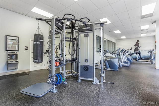 gym featuring a drop ceiling and baseboards