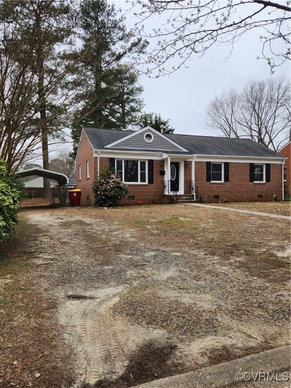 view of front of home with a carport, driveway, and crawl space