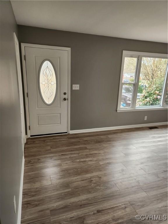 foyer with visible vents, wood finished floors, and baseboards