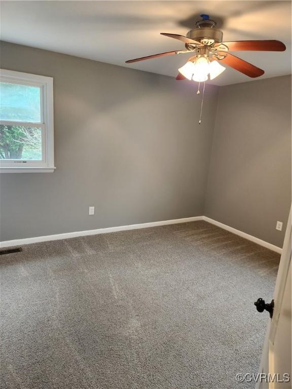 spare room featuring visible vents, carpet floors, baseboards, and ceiling fan