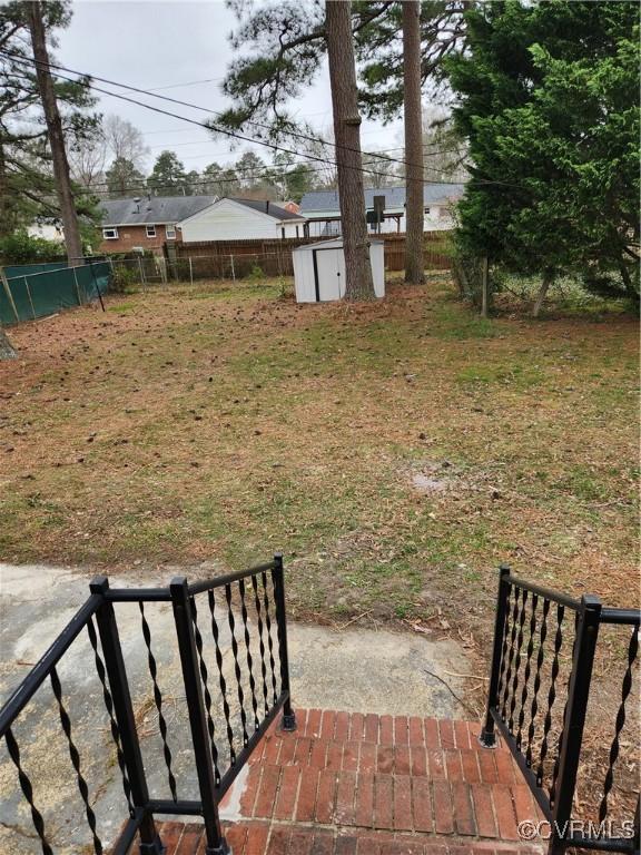 view of yard featuring a patio, an outbuilding, a fenced backyard, and a shed