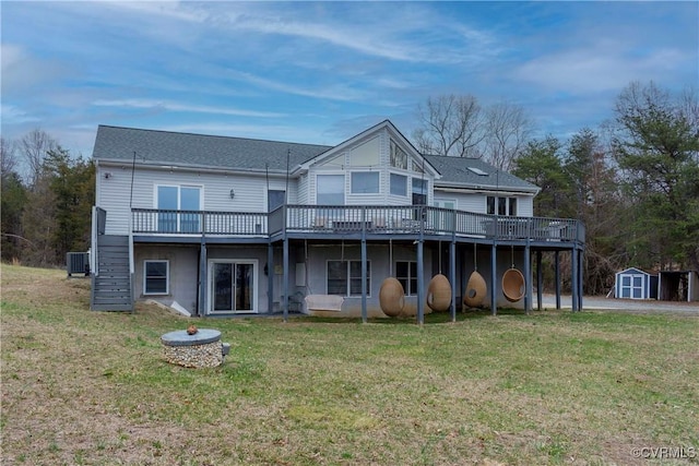 rear view of house with a lawn, a deck, a shed, cooling unit, and an outdoor structure