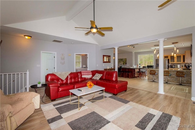 living room featuring light wood finished floors, a ceiling fan, and ornate columns