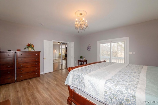 bedroom with light wood-style flooring and a notable chandelier