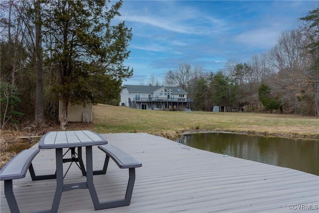 dock area with a lawn and a deck with water view