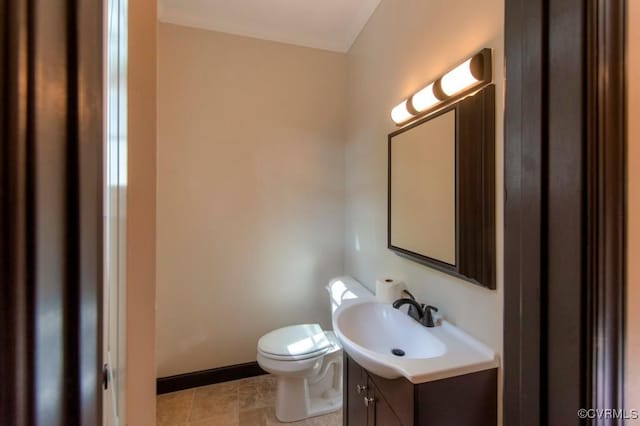 half bathroom featuring tile patterned floors, baseboards, toilet, and vanity