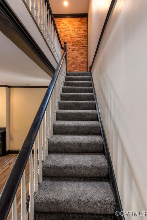 stairway with baseboards and wood finished floors