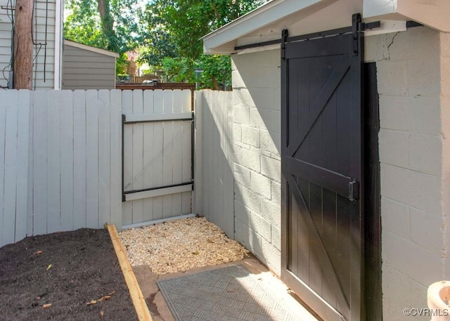 exterior space with concrete block siding, a gate, and fence