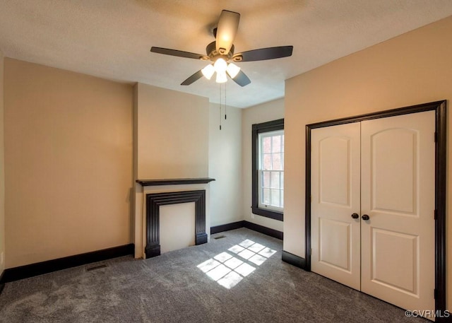 unfurnished bedroom featuring visible vents, ceiling fan, baseboards, carpet floors, and a closet