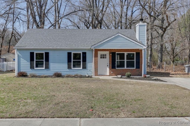 ranch-style home featuring fence, a front yard, a shingled roof, brick siding, and a chimney