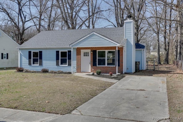 single story home featuring a shingled roof, a front lawn, brick siding, and a chimney