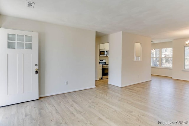 interior space featuring a notable chandelier, visible vents, baseboards, and light wood-style floors