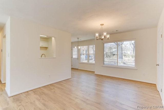 unfurnished dining area featuring light wood-type flooring, baseboards, a notable chandelier, and visible vents