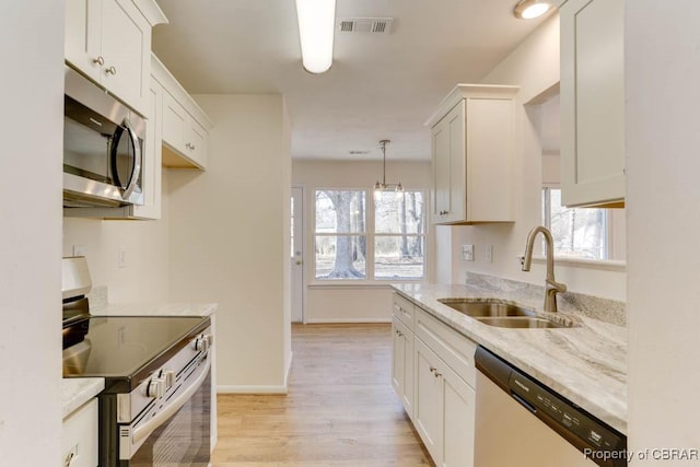 kitchen featuring a sink, stainless steel appliances, visible vents, and a healthy amount of sunlight