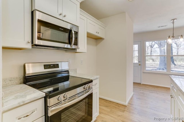 kitchen with visible vents, baseboards, light wood-style flooring, appliances with stainless steel finishes, and white cabinetry